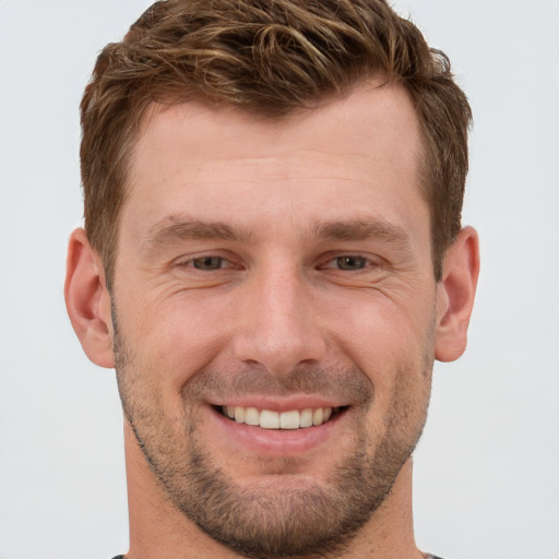 Joyful white young-adult male with short  brown hair and grey eyes