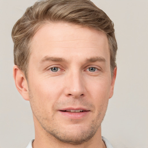 Joyful white young-adult male with short  brown hair and grey eyes