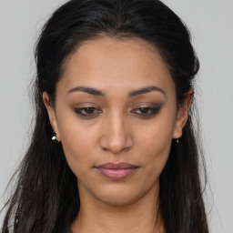 Joyful latino young-adult female with long  brown hair and brown eyes