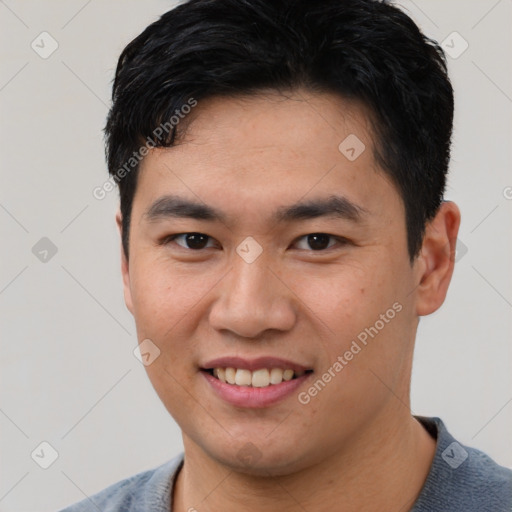 Joyful asian young-adult male with short  black hair and brown eyes