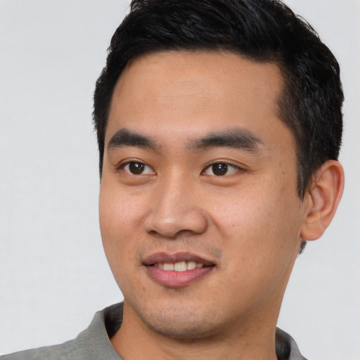 Joyful asian young-adult male with short  black hair and brown eyes