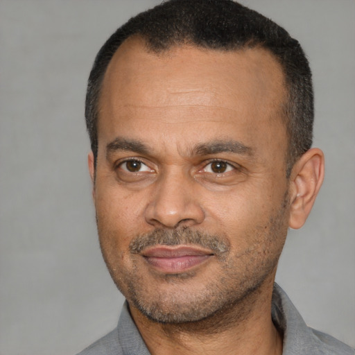 Joyful latino adult male with short  black hair and brown eyes