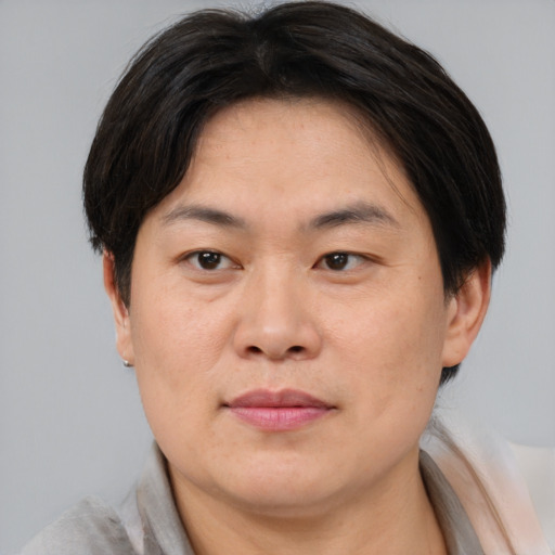 Joyful asian adult male with short  brown hair and brown eyes