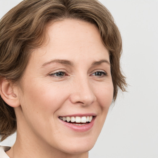 Joyful white young-adult female with medium  brown hair and green eyes