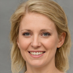 Joyful white young-adult female with medium  brown hair and blue eyes