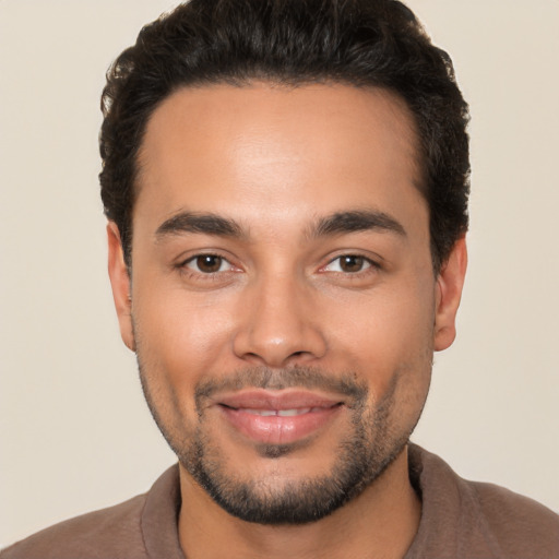 Joyful white young-adult male with short  black hair and brown eyes