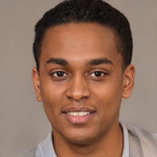 Joyful black young-adult male with short  brown hair and brown eyes