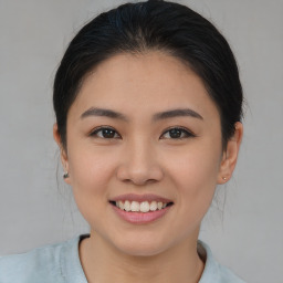 Joyful asian young-adult female with medium  brown hair and brown eyes