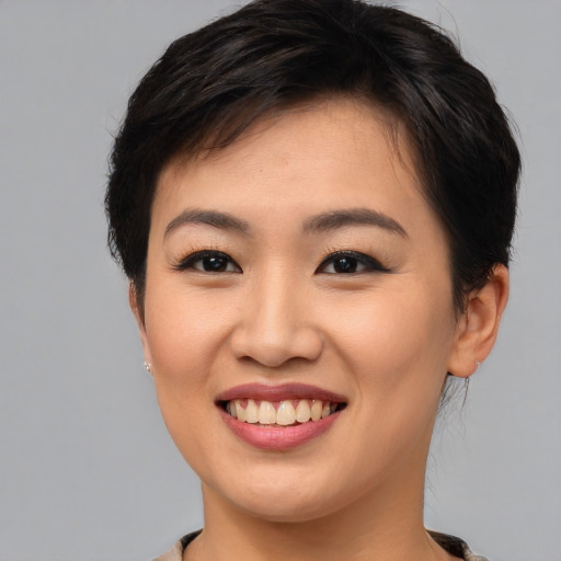 Joyful asian young-adult female with short  brown hair and brown eyes