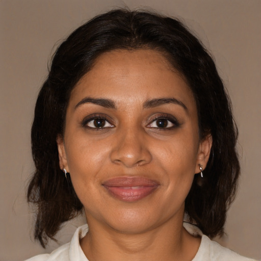 Joyful black adult female with medium  brown hair and brown eyes