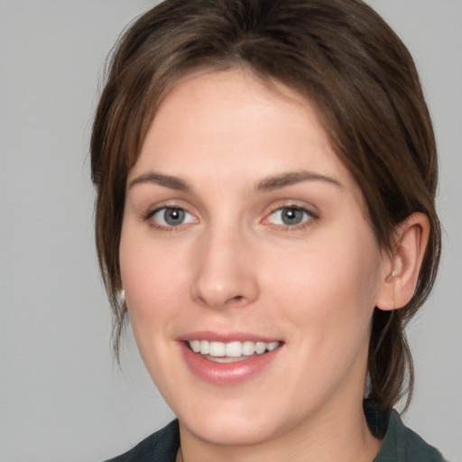 Joyful white young-adult female with medium  brown hair and grey eyes