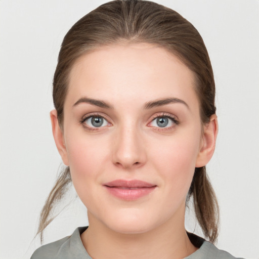 Joyful white young-adult female with medium  brown hair and grey eyes