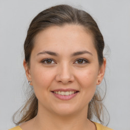 Joyful white young-adult female with medium  brown hair and brown eyes