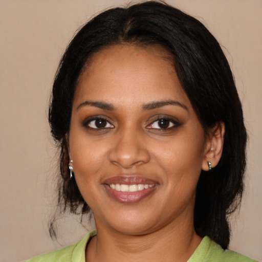 Joyful black young-adult female with long  black hair and brown eyes