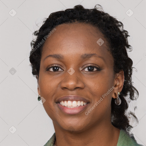 Joyful black young-adult female with long  black hair and brown eyes