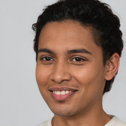 Joyful latino young-adult male with short  black hair and brown eyes