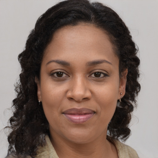 Joyful black young-adult female with long  brown hair and brown eyes