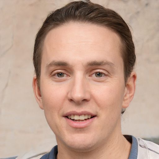 Joyful white adult male with short  brown hair and grey eyes