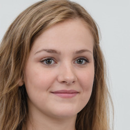 Joyful white young-adult female with long  brown hair and green eyes