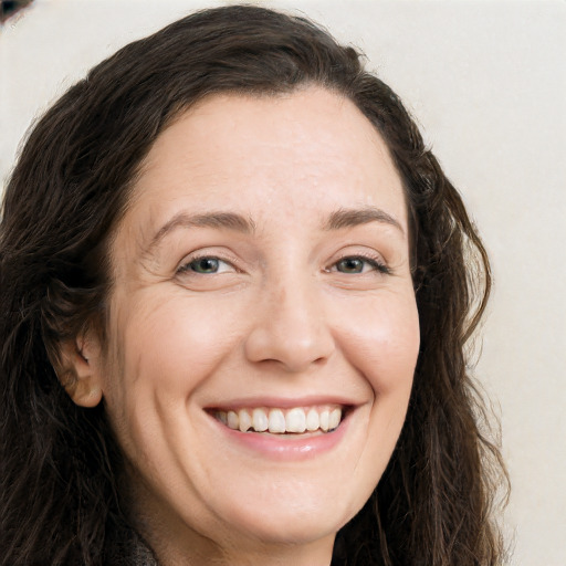 Joyful white adult female with long  brown hair and brown eyes