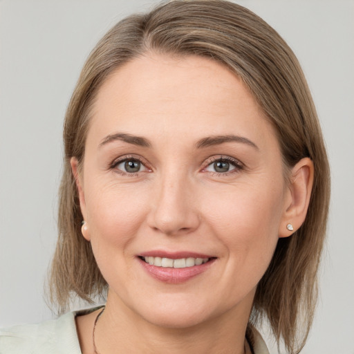 Joyful white young-adult female with medium  brown hair and grey eyes