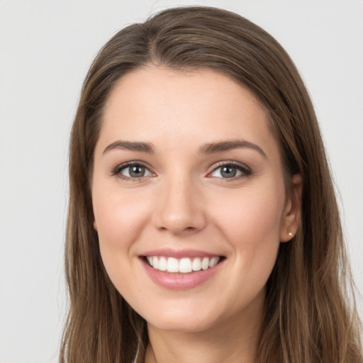 Joyful white young-adult female with long  brown hair and grey eyes