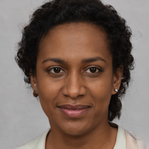 Joyful black adult female with short  brown hair and brown eyes