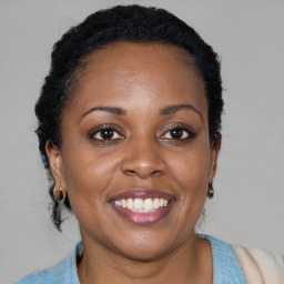 Joyful black young-adult female with short  black hair and brown eyes