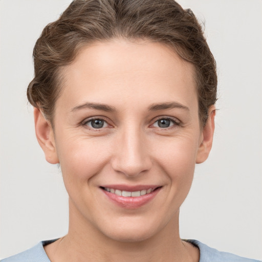 Joyful white young-adult female with short  brown hair and grey eyes