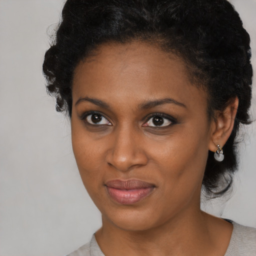 Joyful black young-adult female with medium  black hair and brown eyes
