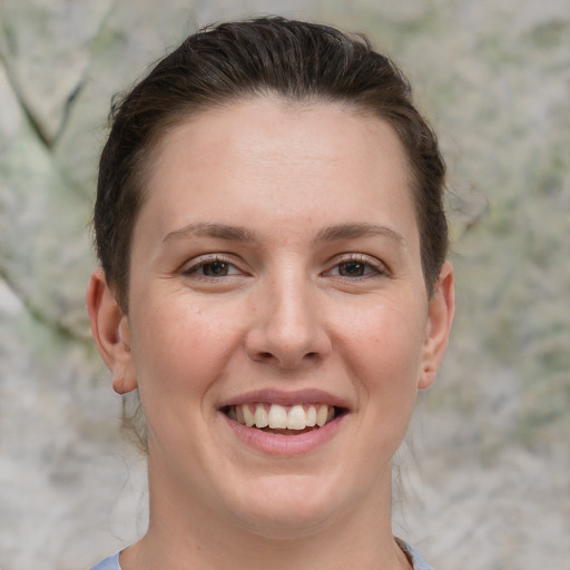 Joyful white young-adult female with short  brown hair and grey eyes