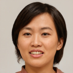 Joyful asian young-adult female with medium  brown hair and brown eyes