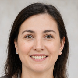 Joyful white adult female with long  brown hair and brown eyes