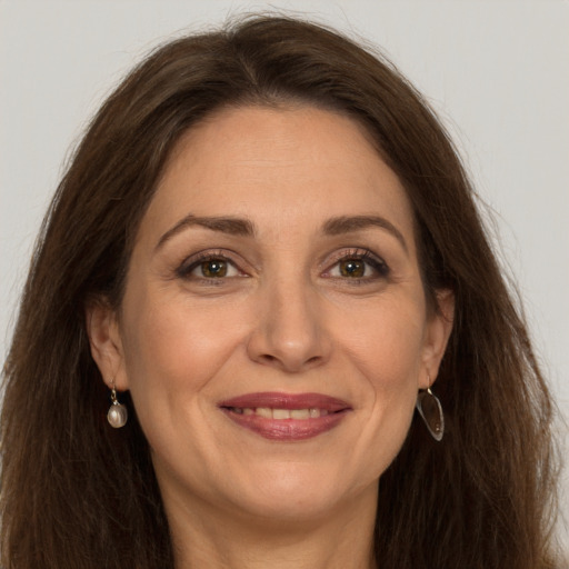 Joyful white adult female with long  brown hair and grey eyes