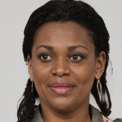 Joyful black adult female with long  black hair and brown eyes