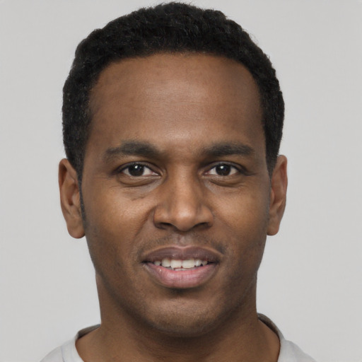 Joyful black young-adult male with short  black hair and brown eyes