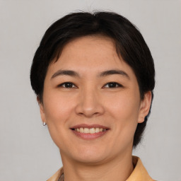 Joyful asian young-adult female with short  brown hair and brown eyes