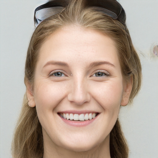 Joyful white young-adult female with long  brown hair and blue eyes