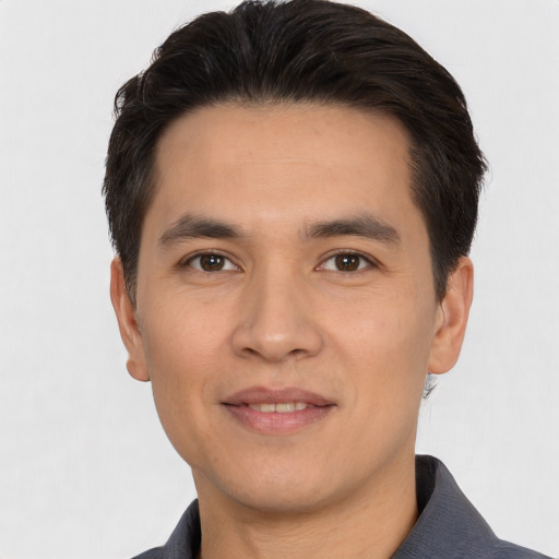 Joyful white young-adult male with short  black hair and brown eyes