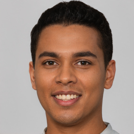 Joyful latino young-adult male with short  black hair and brown eyes