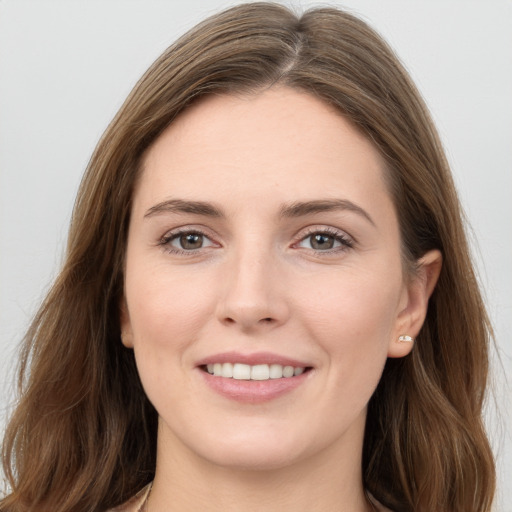 Joyful white young-adult female with long  brown hair and grey eyes