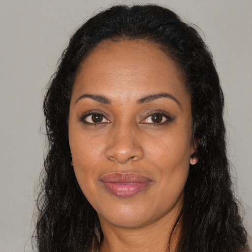 Joyful black young-adult female with long  brown hair and brown eyes