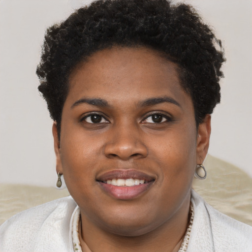 Joyful black young-adult female with short  brown hair and brown eyes