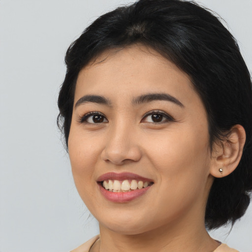 Joyful asian young-adult female with medium  black hair and brown eyes