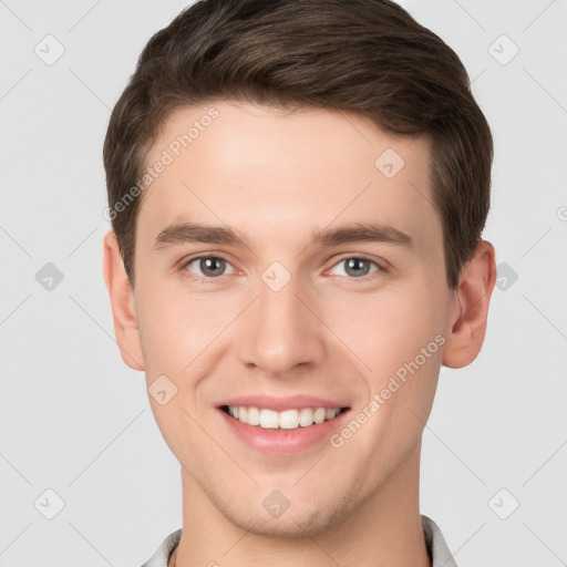 Joyful white young-adult male with short  brown hair and grey eyes