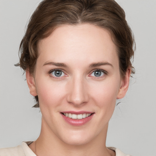 Joyful white young-adult female with medium  brown hair and grey eyes