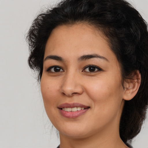 Joyful latino young-adult female with medium  brown hair and brown eyes