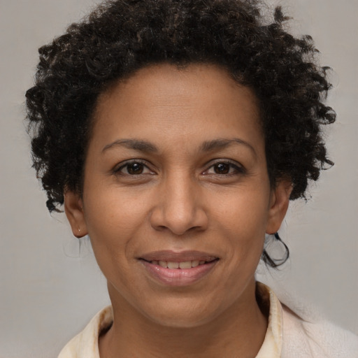 Joyful black adult female with short  brown hair and brown eyes