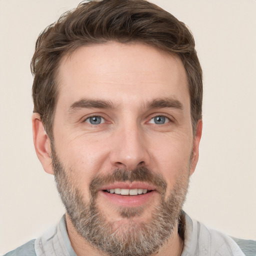 Joyful white adult male with short  brown hair and grey eyes