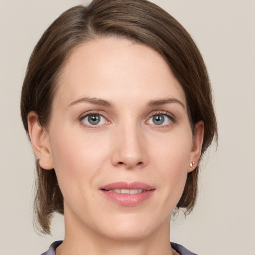 Joyful white young-adult female with medium  brown hair and grey eyes